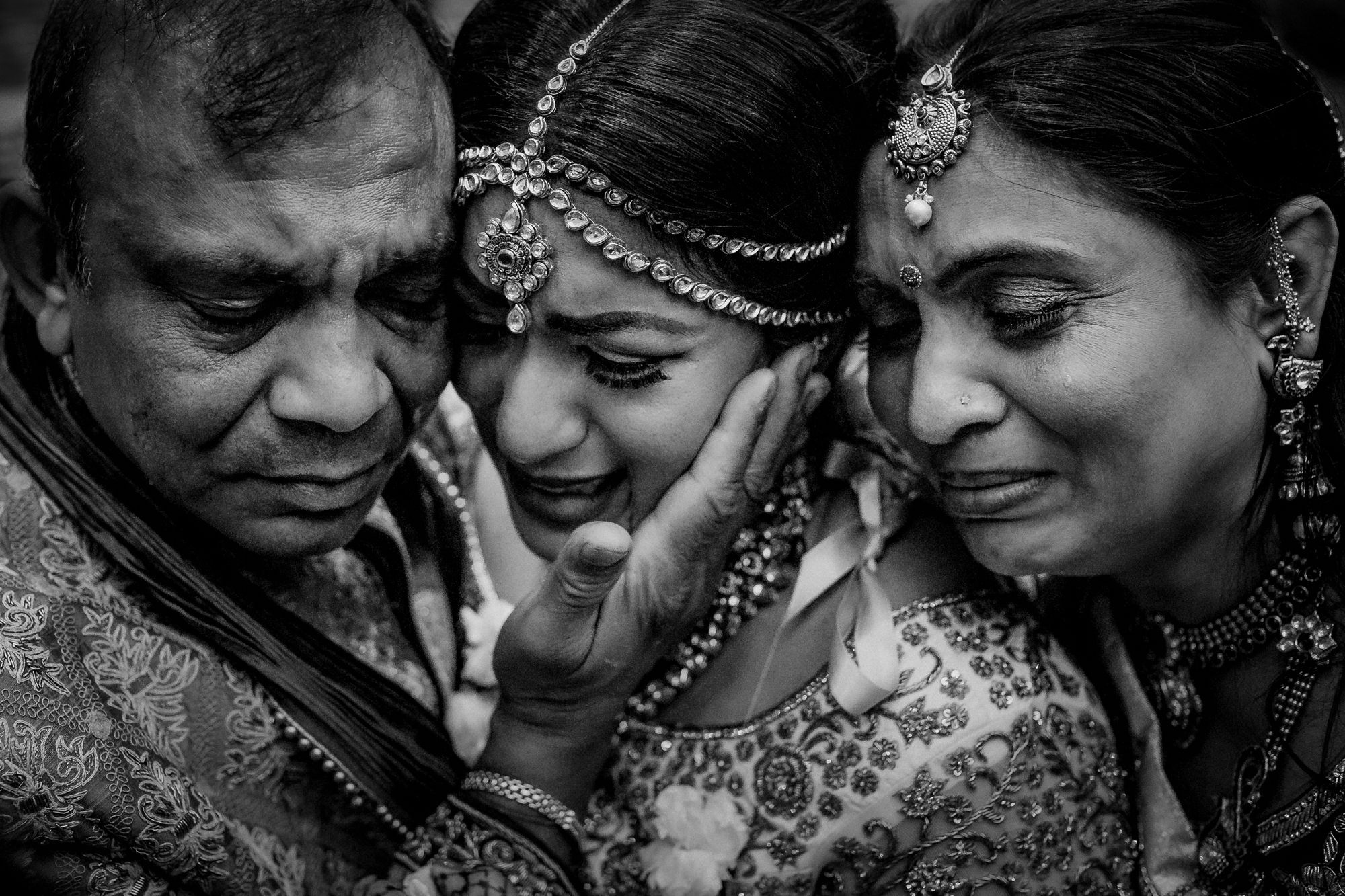 Indian bride embracing mom and dad in emotional moment by Matei Horvath of Los Angeles