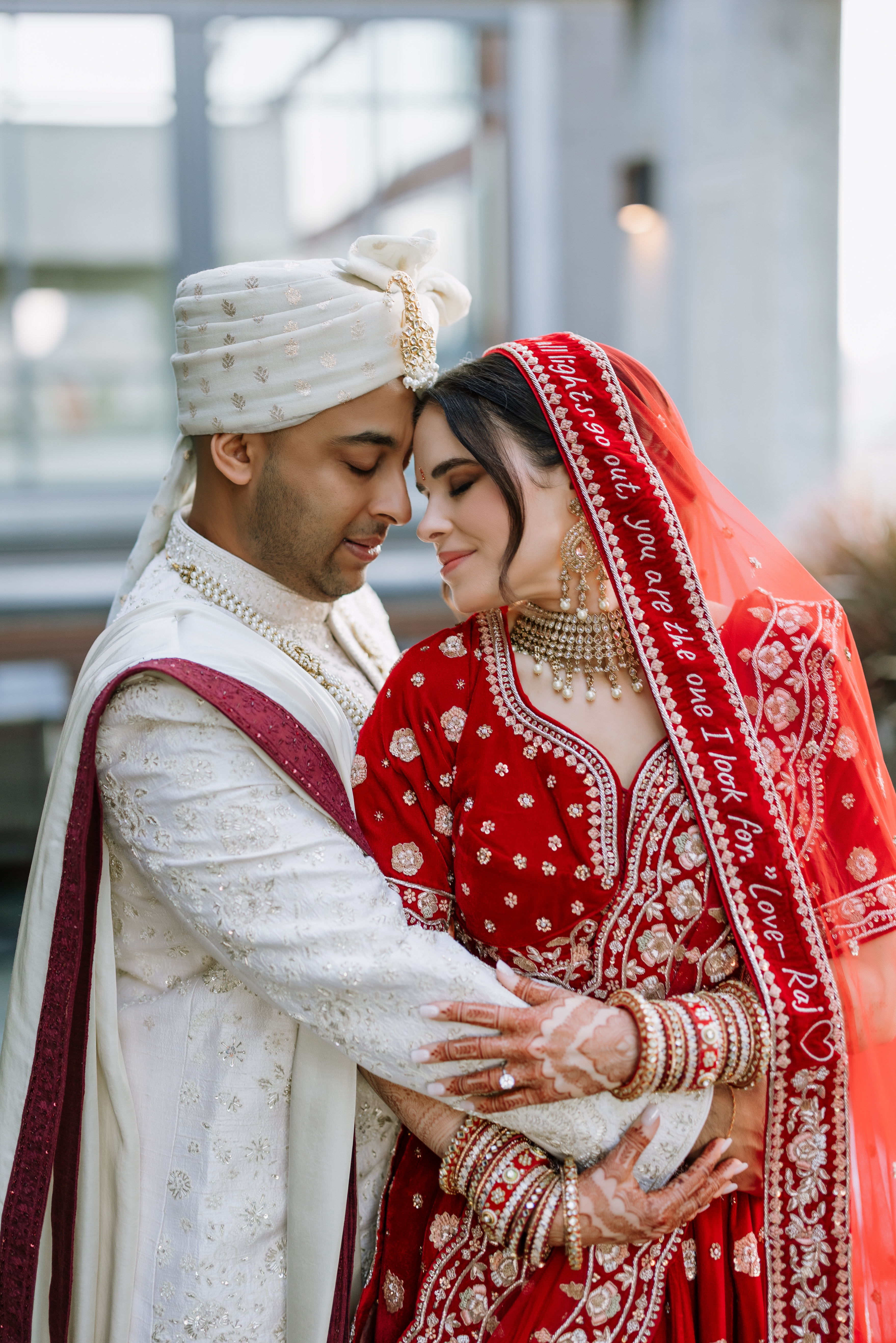 bride and groom in red lehenga and ivory sherwani-Lusia Studio Photography