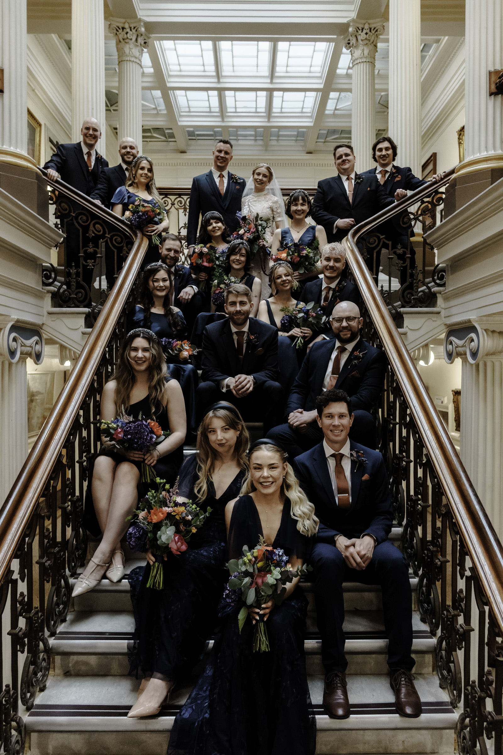 Group shot on stairway Oliver Holder Bristol wedding photographer