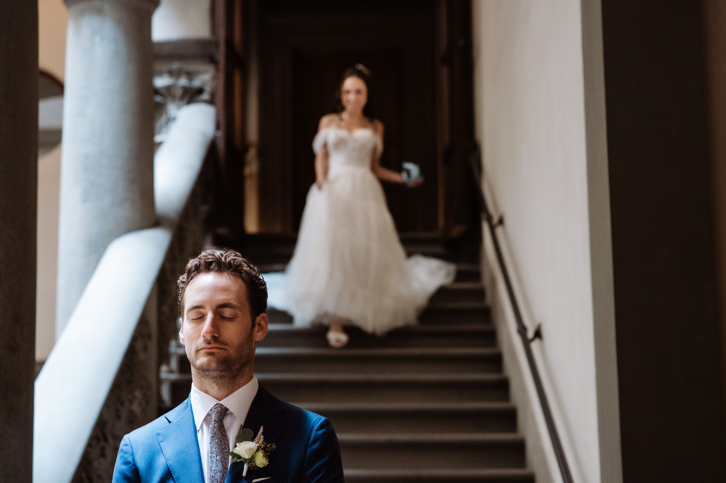 groom-awaiting-first-look-as-bride-descends-stairway-best-wedding-photographer-italy-edoardo-agresti-photographers