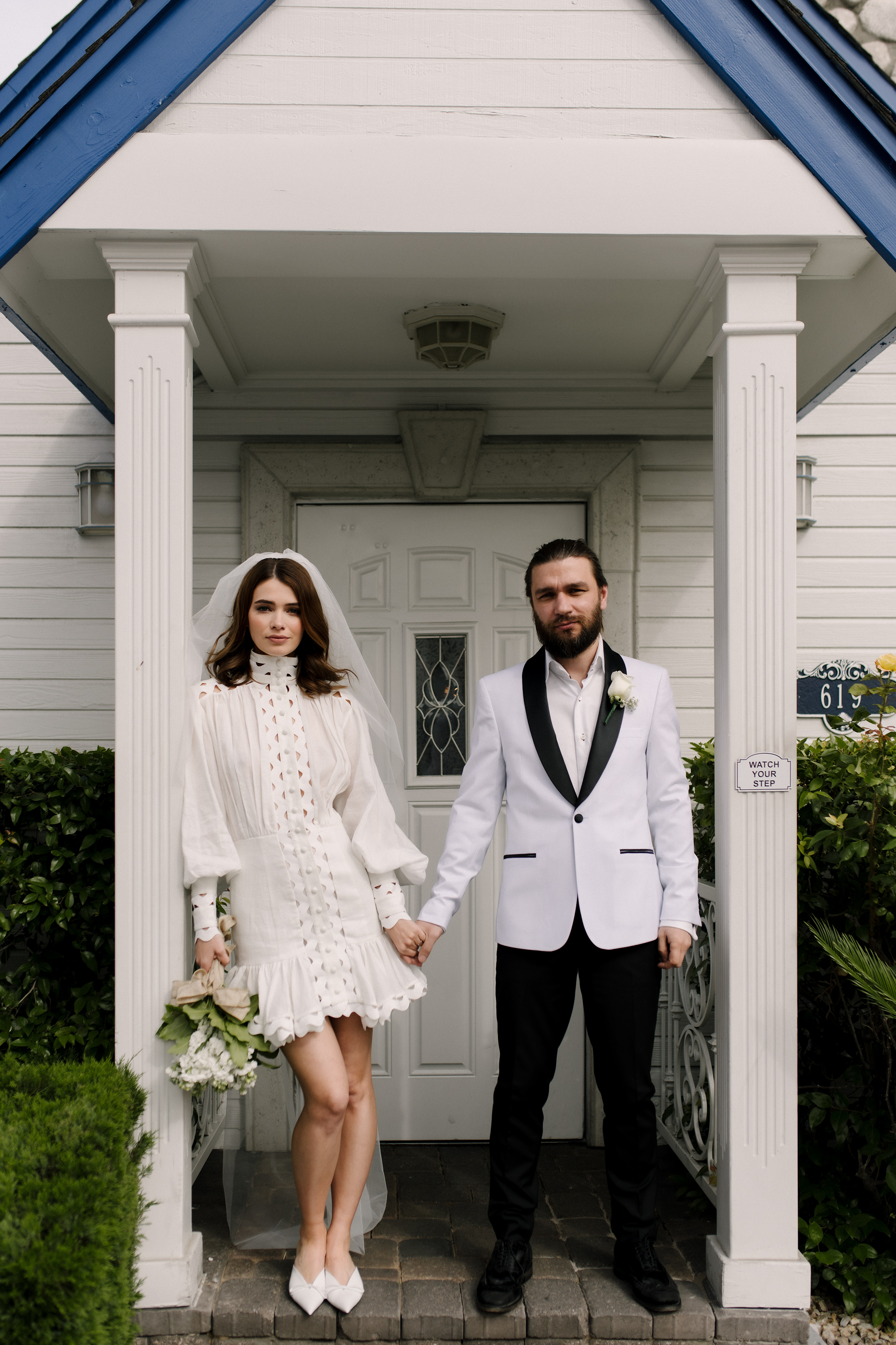 bride-and-groom-standing-in-front-of-chapel-photo-by-matei-horvath-photography