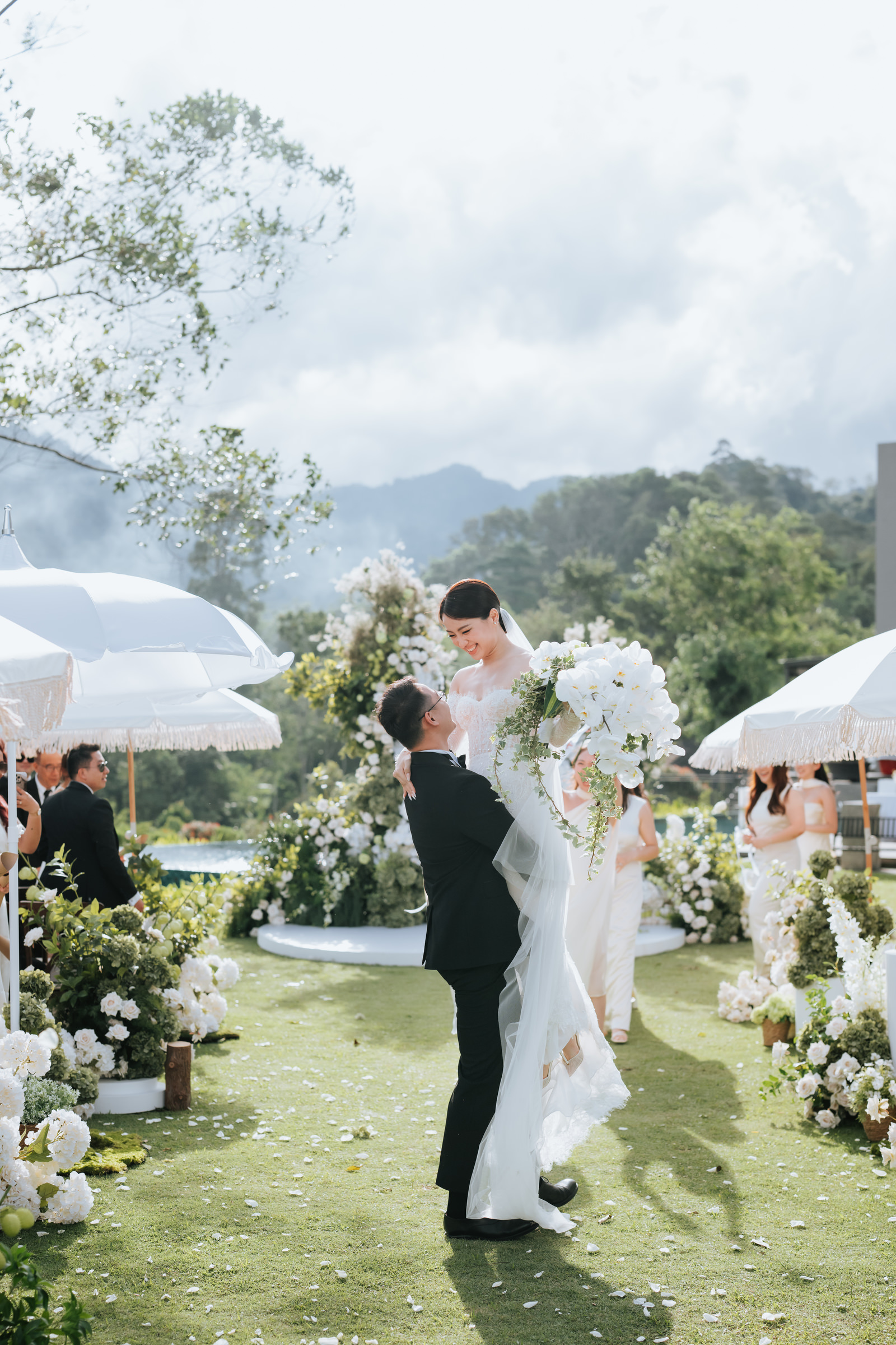 Groom lifts bride in the air during wedding at Acres Resort photographed by Zach Chin