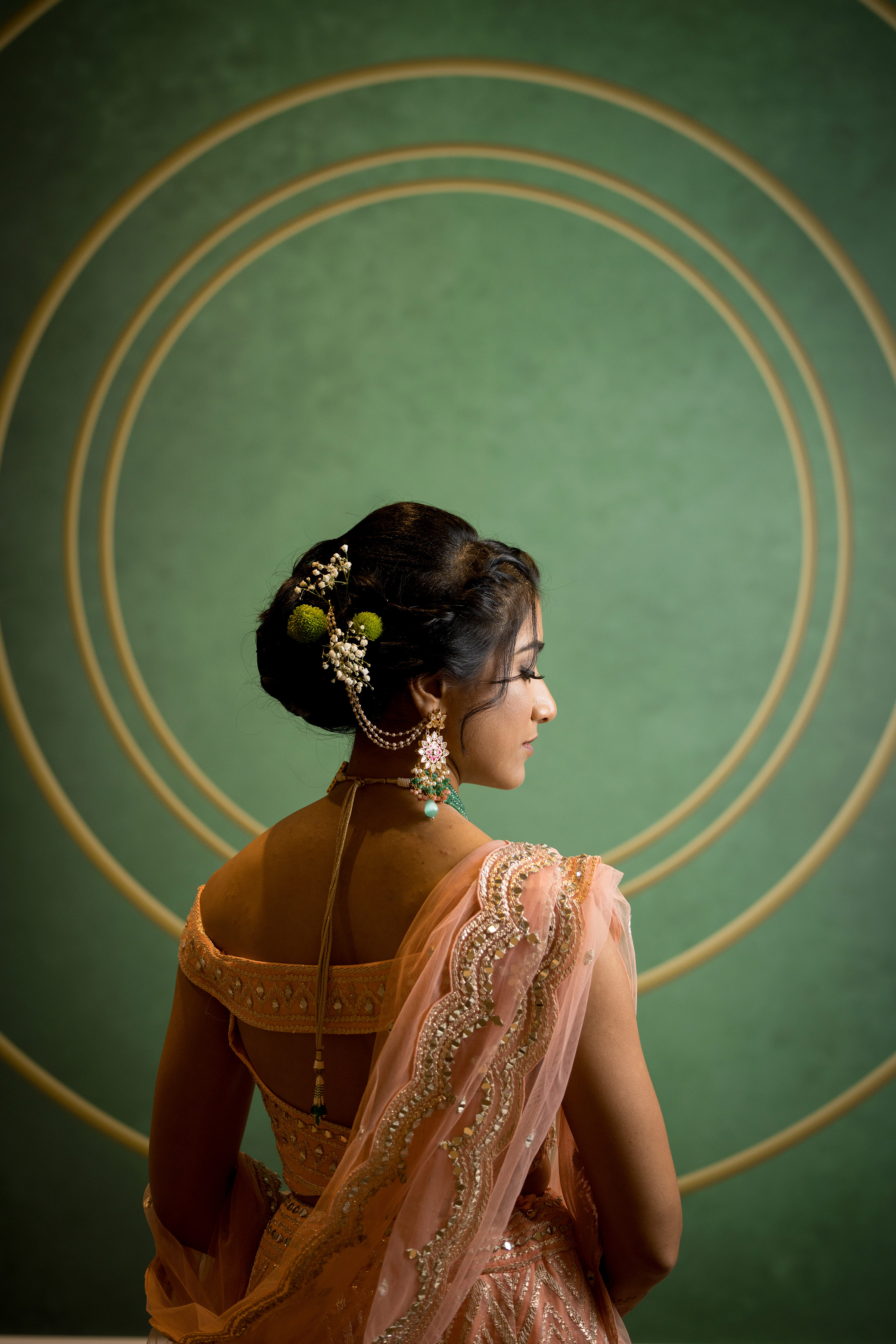 back profile of Indian bride framed against green wall Akbar Sayed Photography 