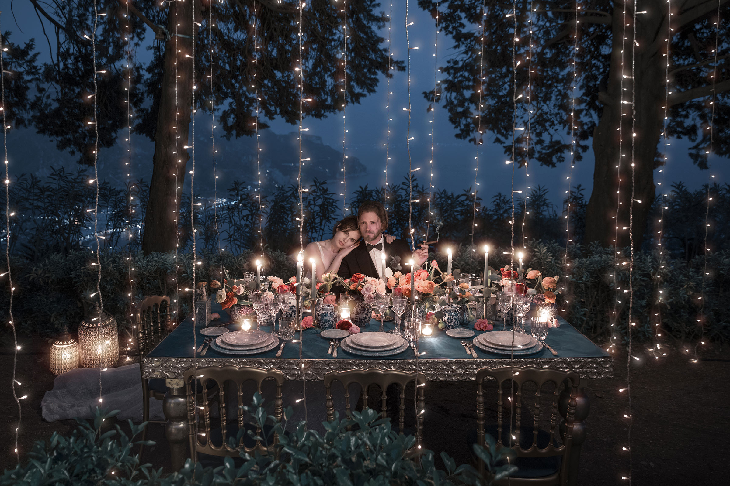 couple-at-outdoor-reception-table-in-evening-candlelight-with-string-lights-best-wedding-photographer-italyjoanne-dunn-photographers