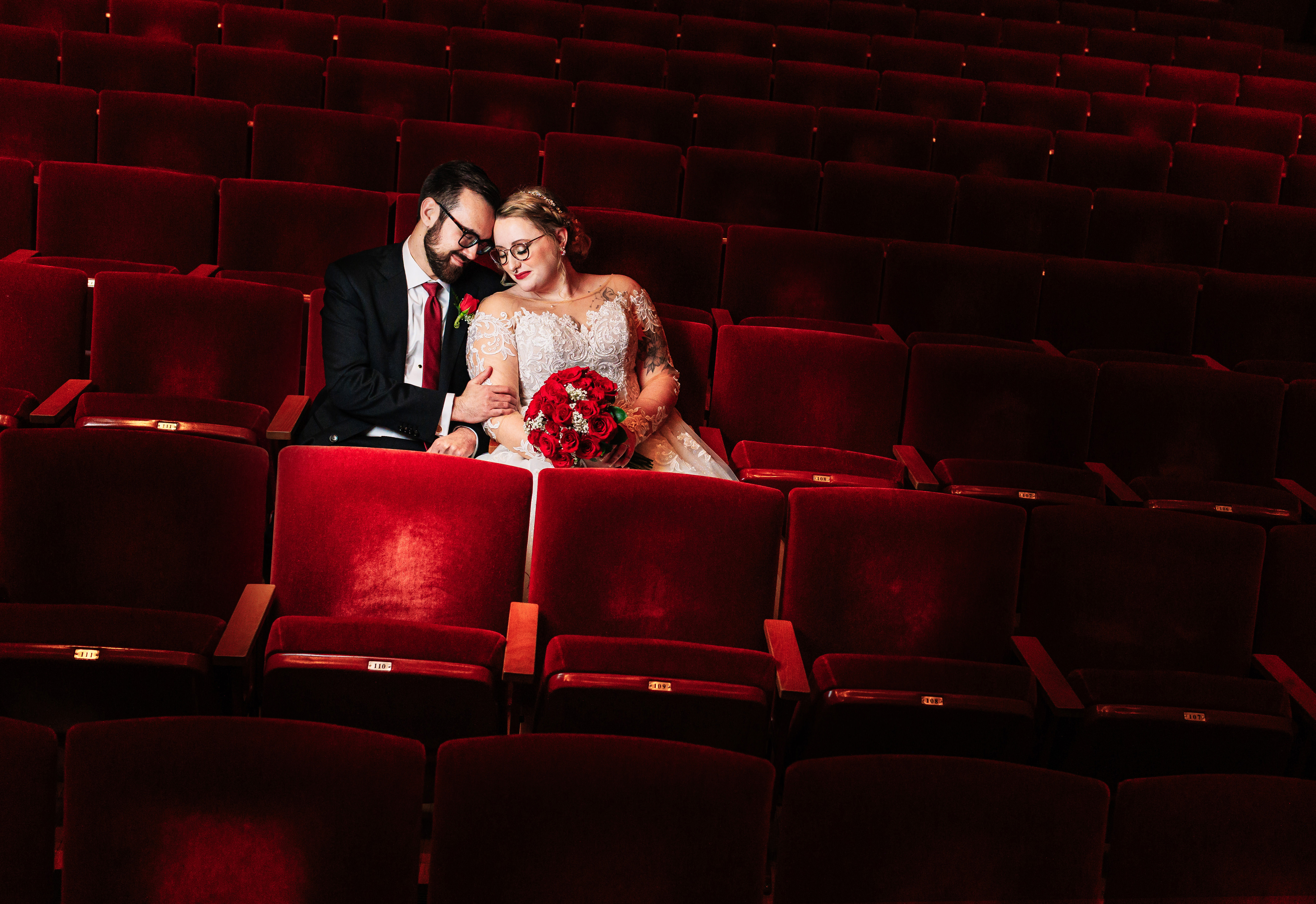 Couple in red velvet theater seats Photography by Brea