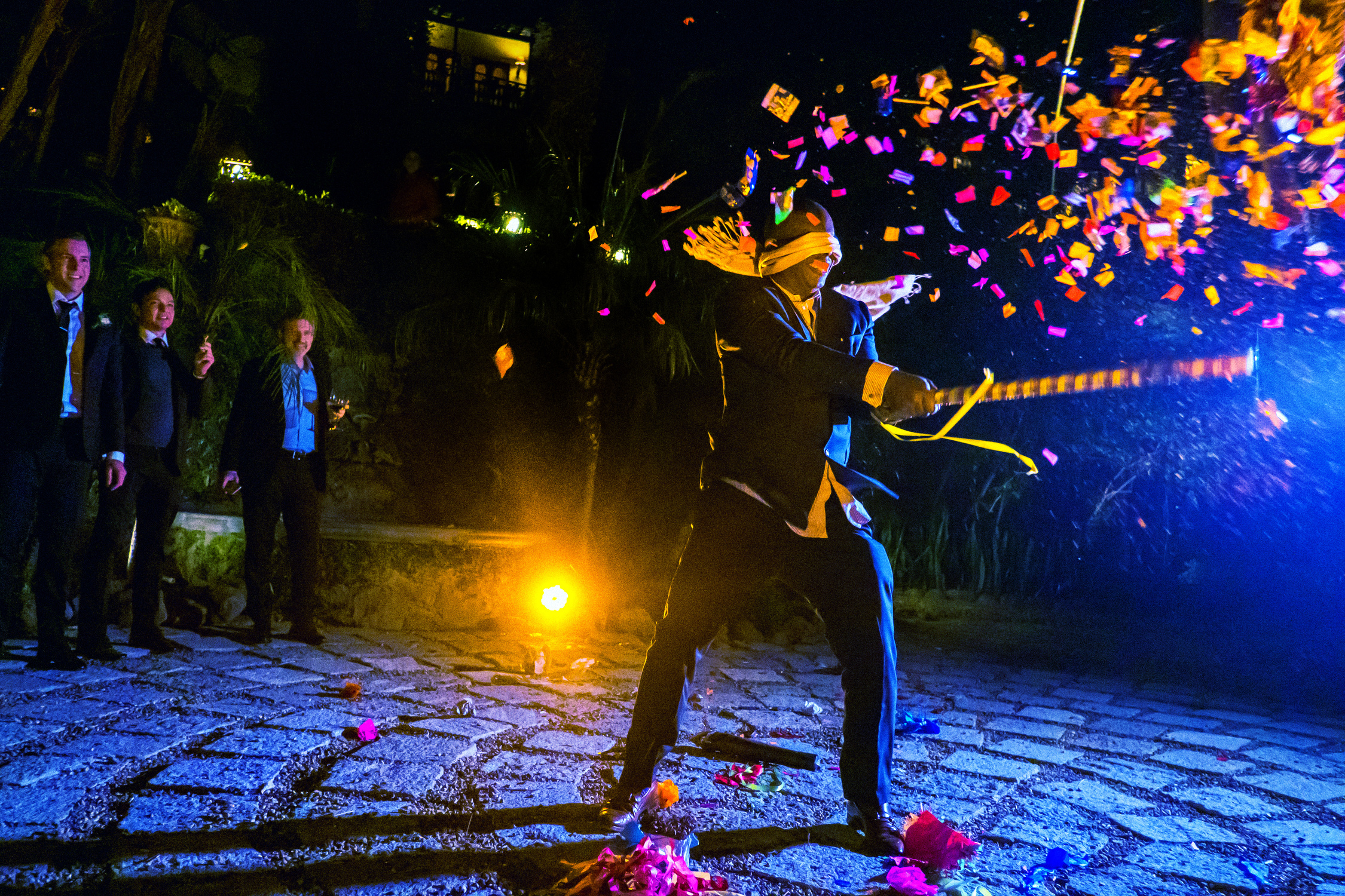 Blindfolded groom whacking pinata during wedding by Annie Bang of Los Angeles