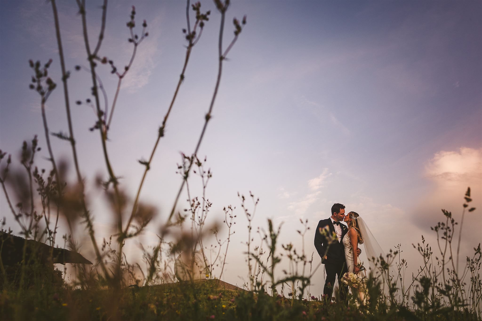 portrait-of-couple-kissing-on-italian-hillside-best-wedding-photographer-italy-livio-lacurre-photography-italy
