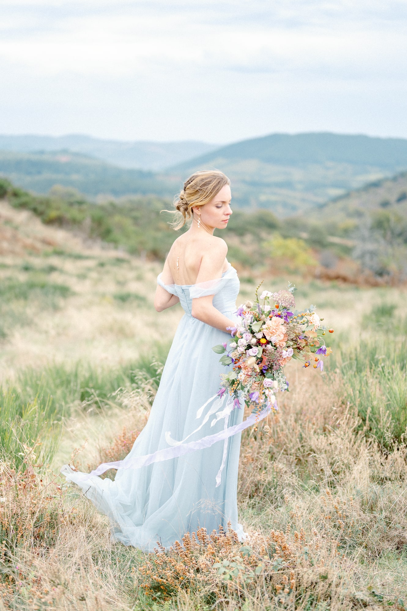Bride in landscape in light blue gown