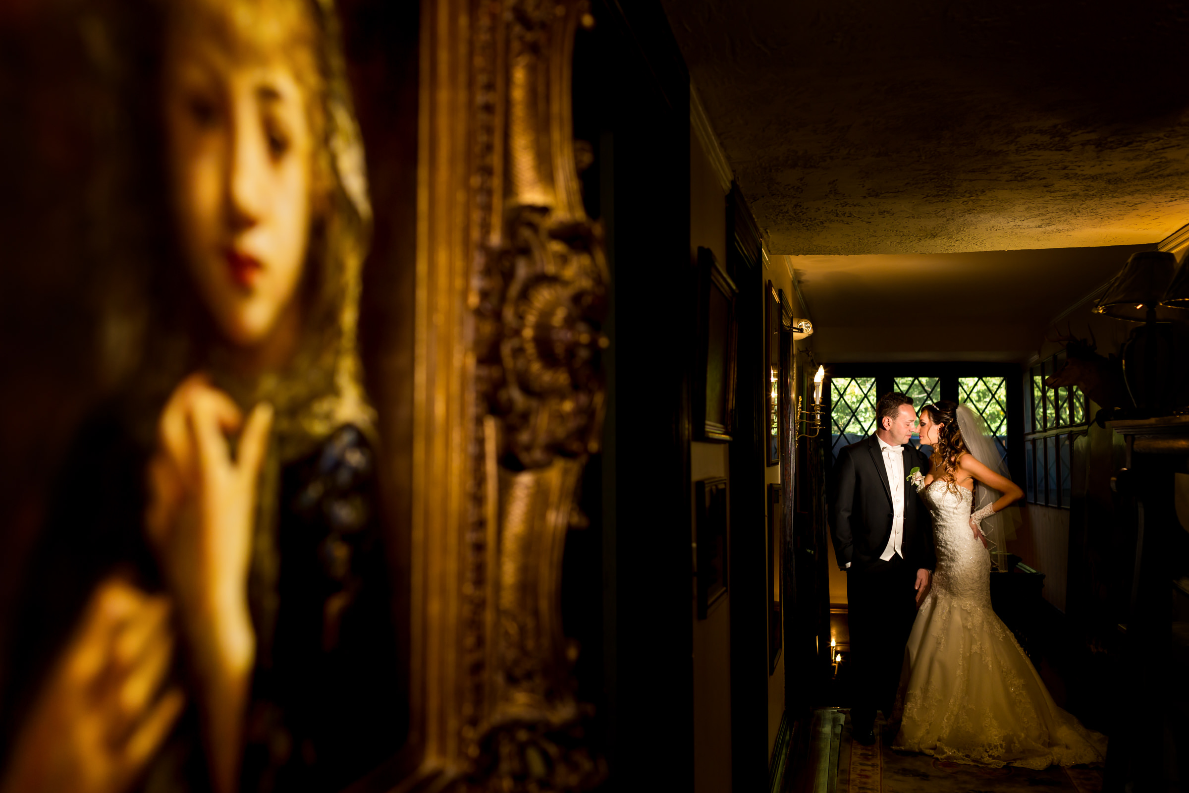 Dramatic light couple portrait against paintings Procopio Photography