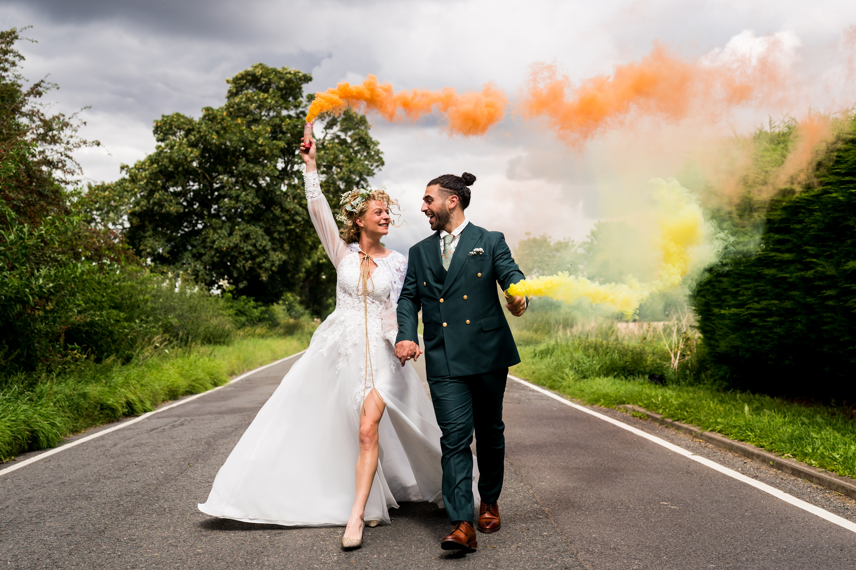 Couple wallking down road with colorful smoke flares
