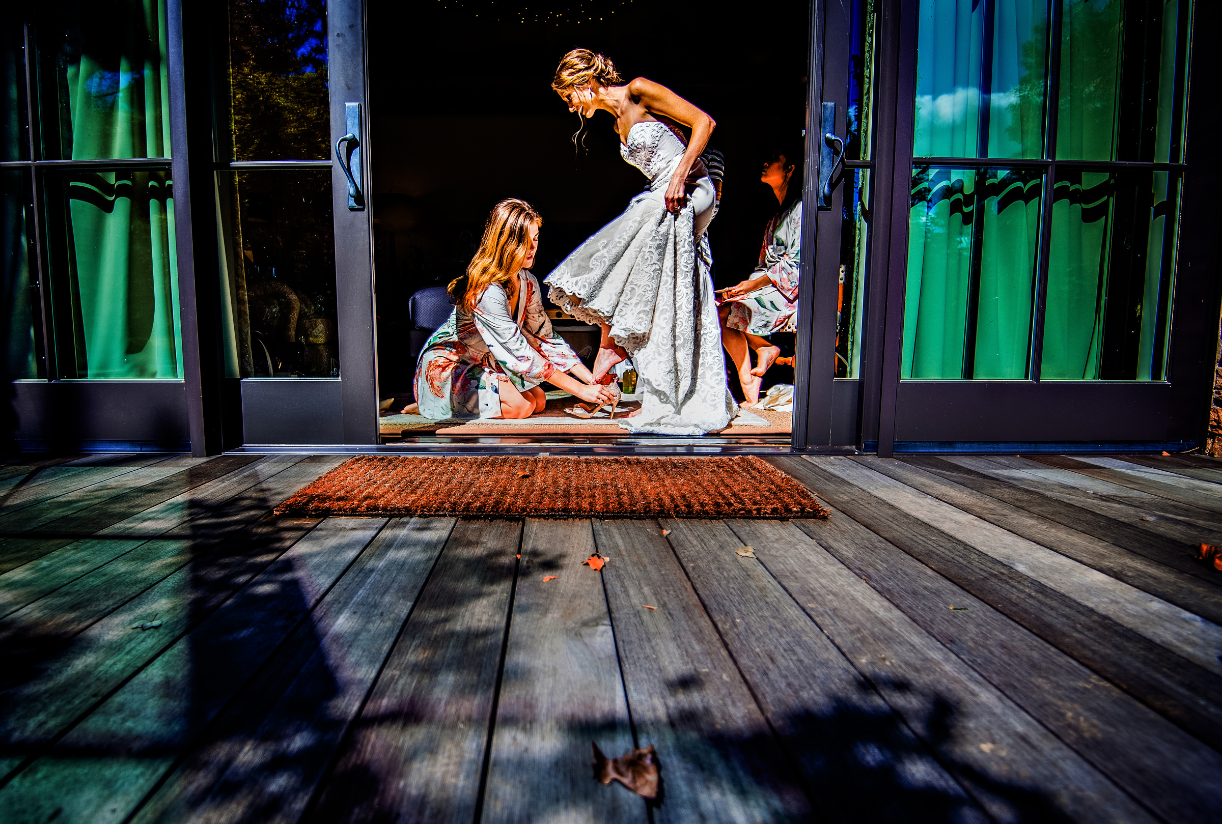 bridesmaids-buckling-brides-shoes-seen-through-doorway-jeff-tisman-photography-new-york