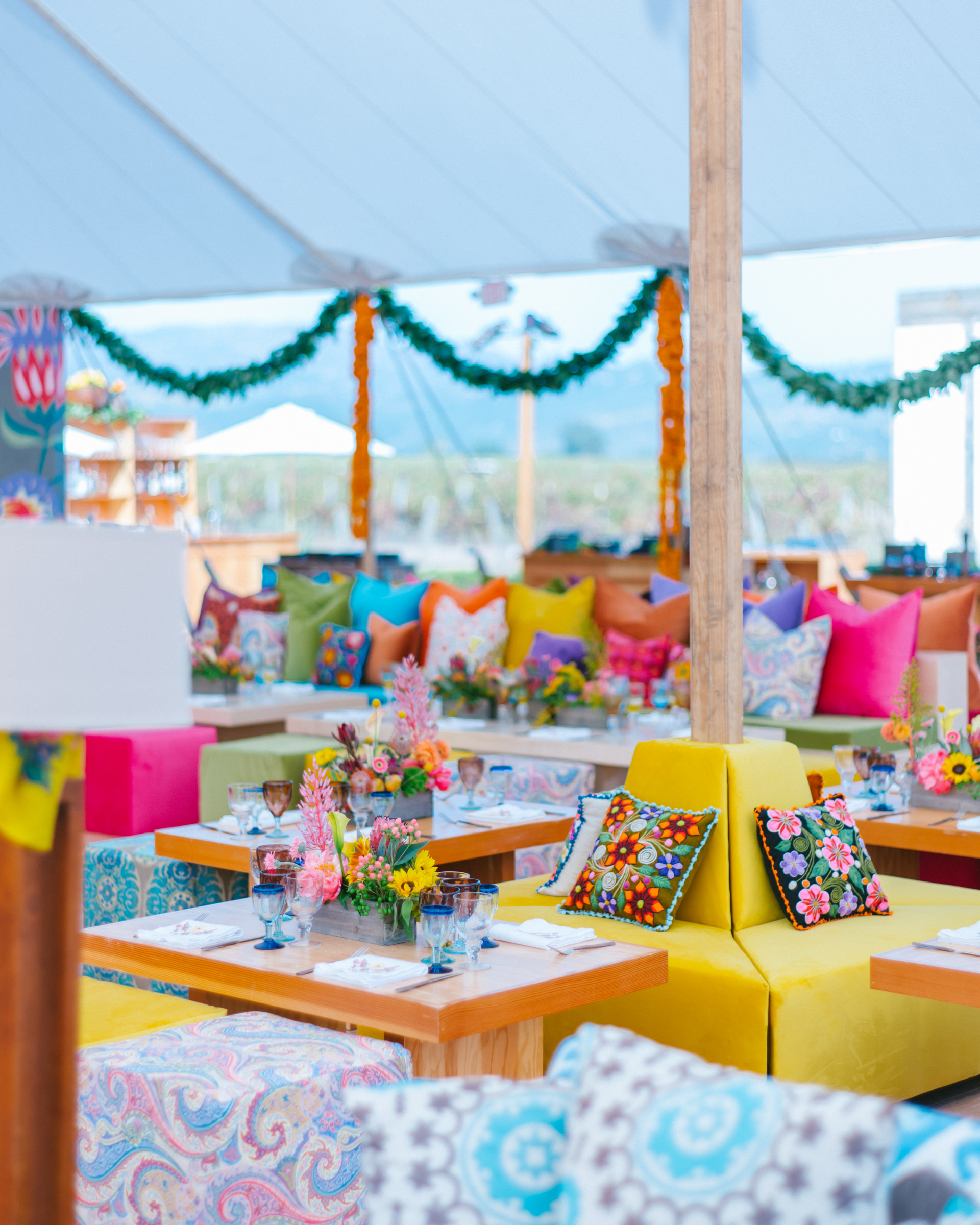 Bright, summery tent with floral pillows and pink Protea flowers