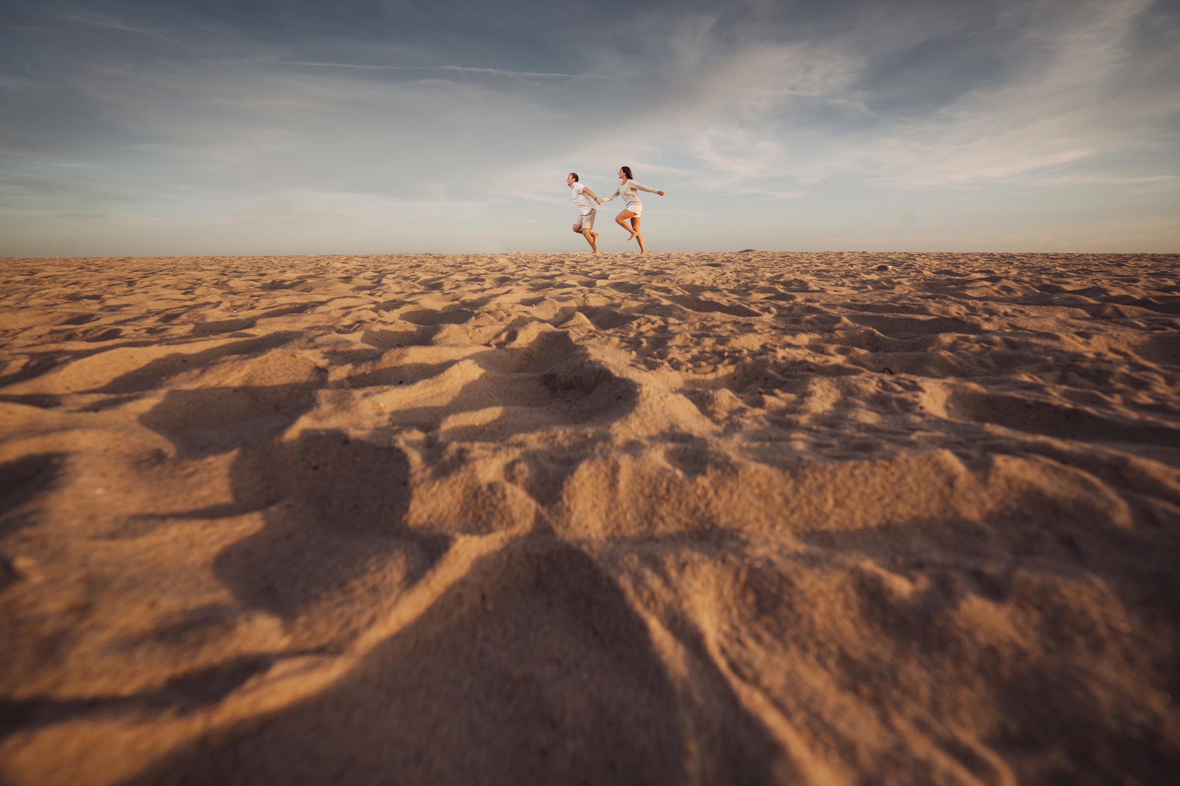 creative-landscape-composition-of-couple-running-on-sand-ein-photography-and-design