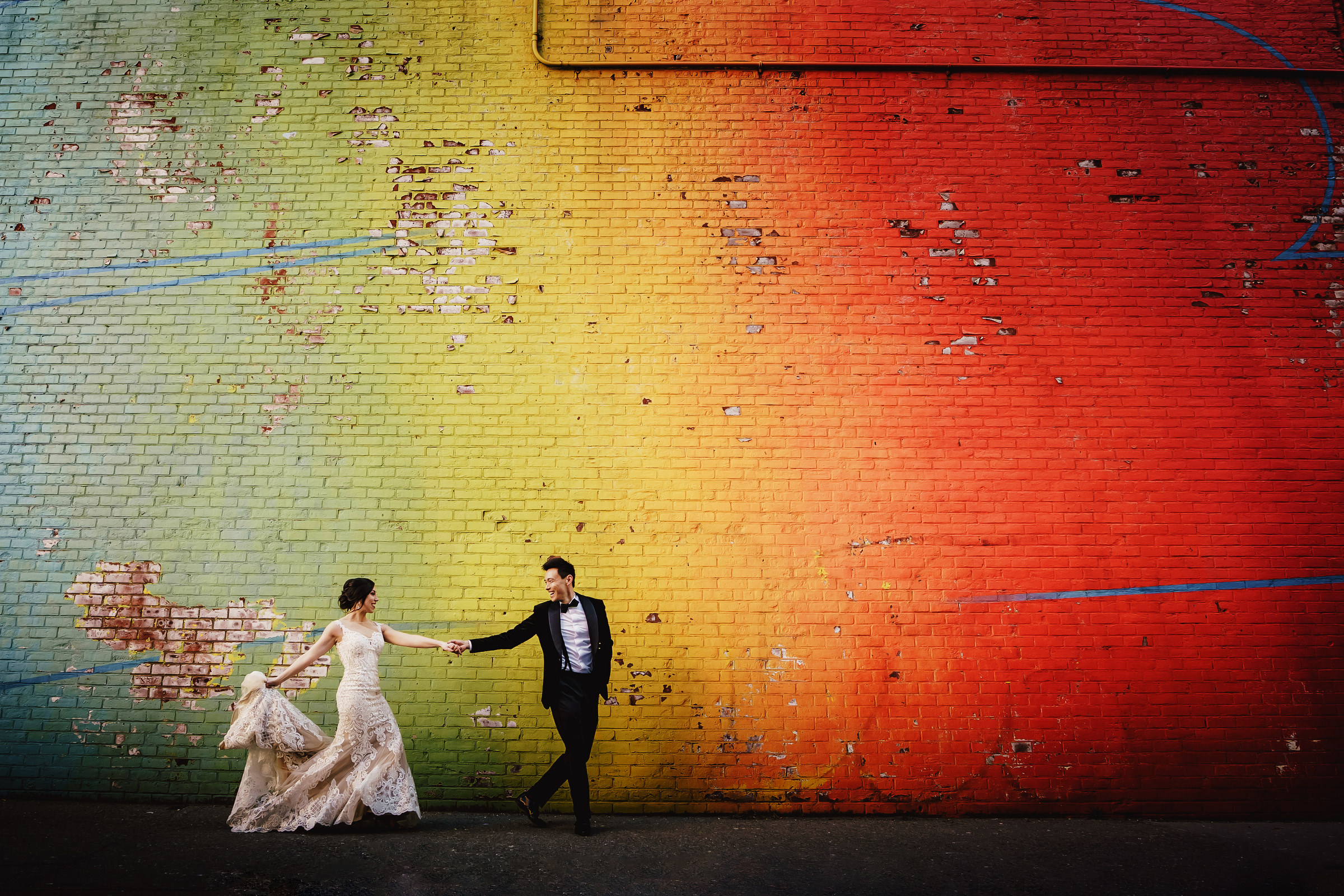 dynamic-couple-against-painted-exterior-wall-ein-photography-and-design