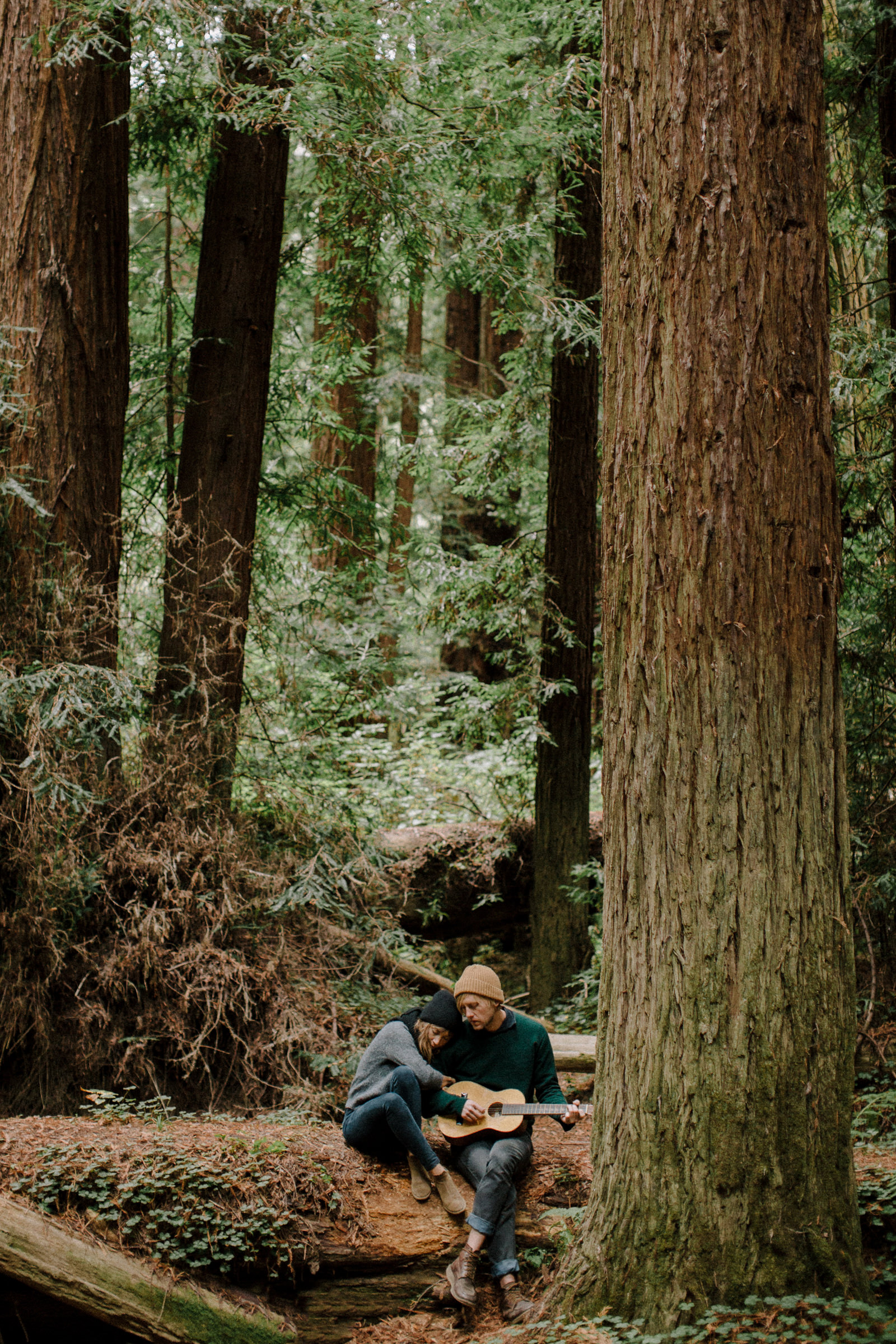Couple playing guitar in forest by Nirav Patel of San Francisco
