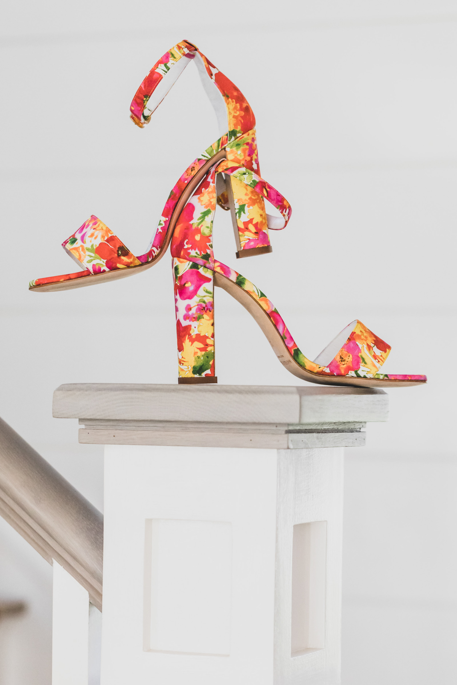 Sandals with red, pink, and yellow floral pattern photographed by Katie Kaiser