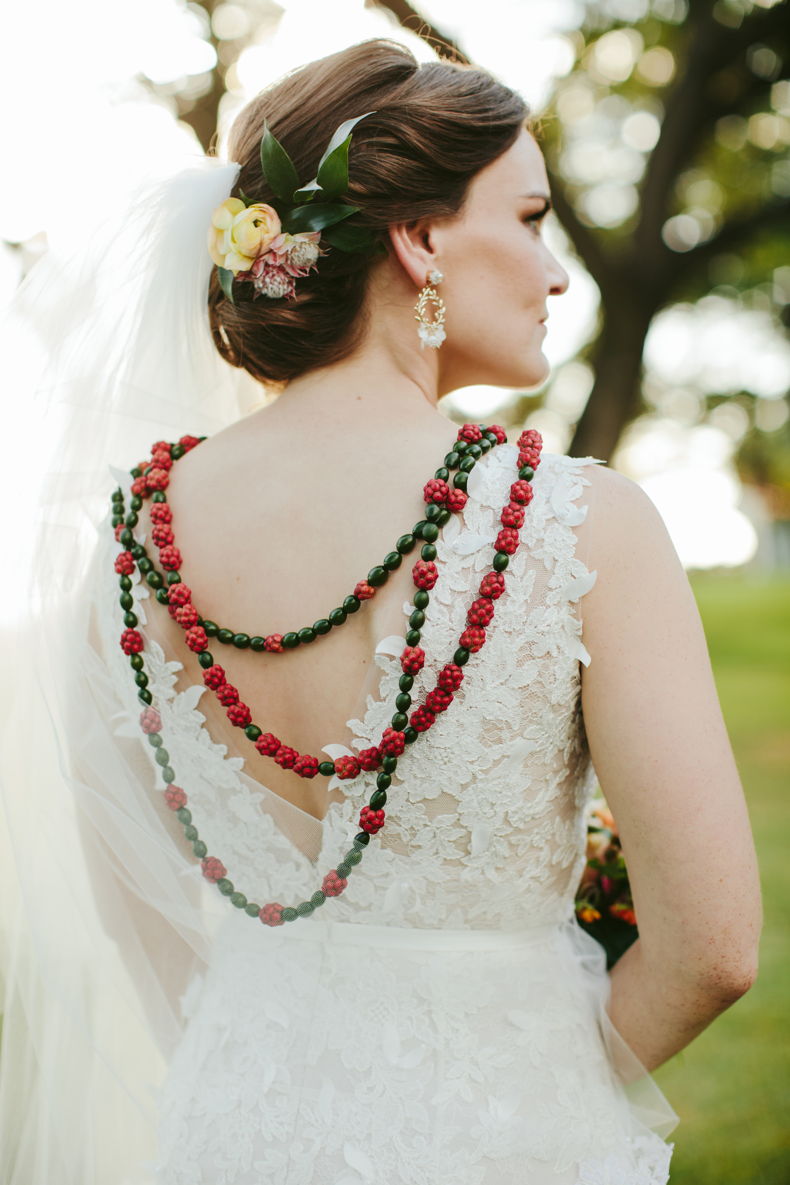 Bride with red and green Hawaiian jewelry photographed by Melia Lucida - Maui