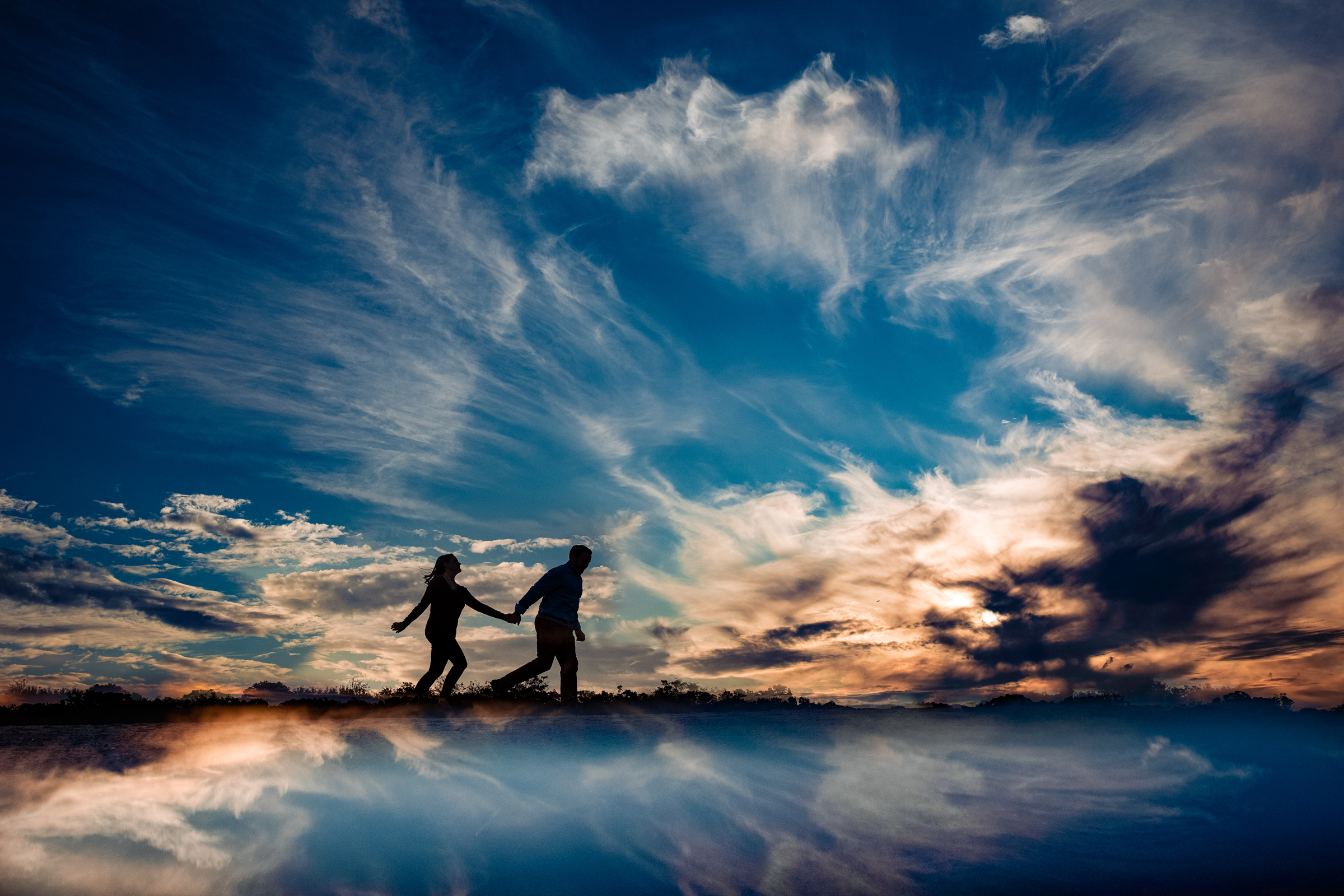 silhouette-couple-walking-through-epic-clouds-reflected-yun-li-photography