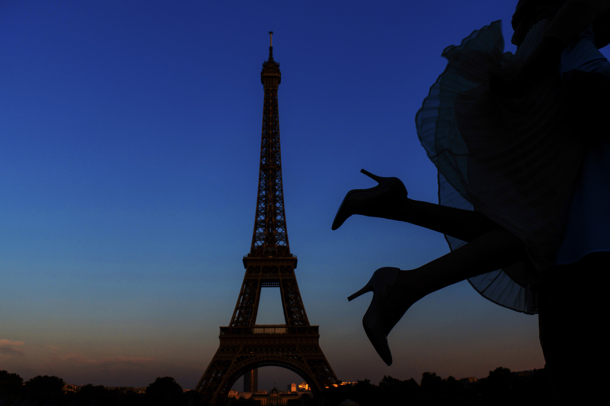 Silhouette of bride kicking up heels against Eiffel Tower skyline by Look Fotografia from Los Angeles