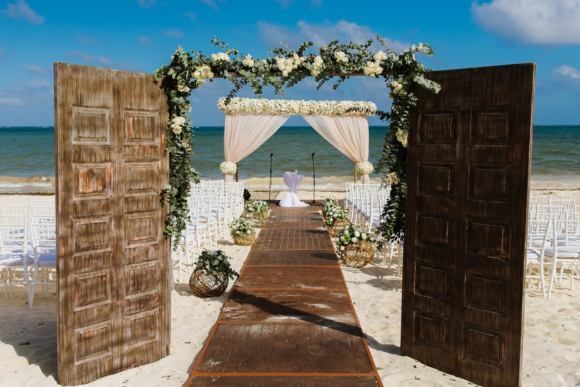 Ceremony decor at the beach with doors and white floral arbor, by ...