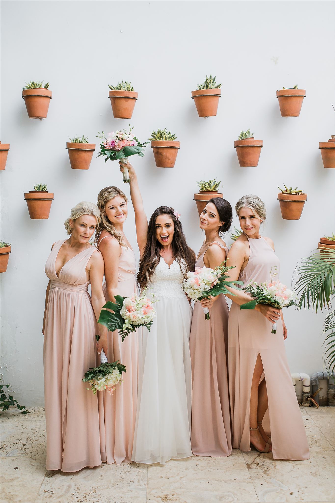 Bridal party with wall of terracotta pots - photo by Jenna Brisson Photography
