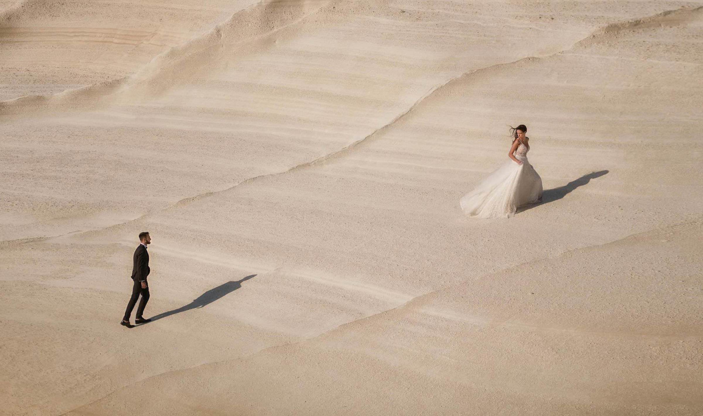 Bride and groom walking in sand dunes - photo by John Makris Photography-Greece wedding photographer Bride and groom walking in sand dunes - photo by John Makris Photography-Greece wedding photographer