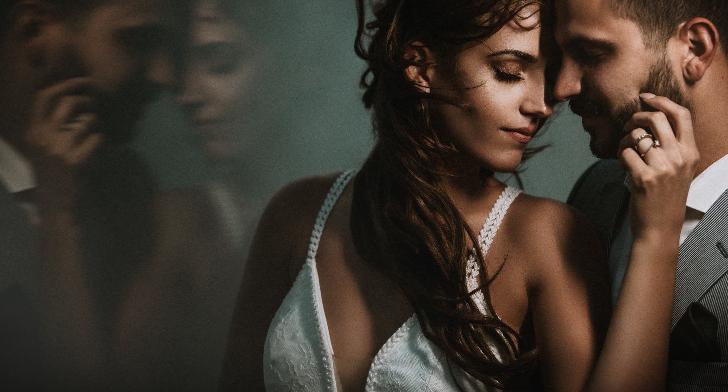 Sultry bride with groom and reflection- photo by John Makris Photography-Greece wedding photographer