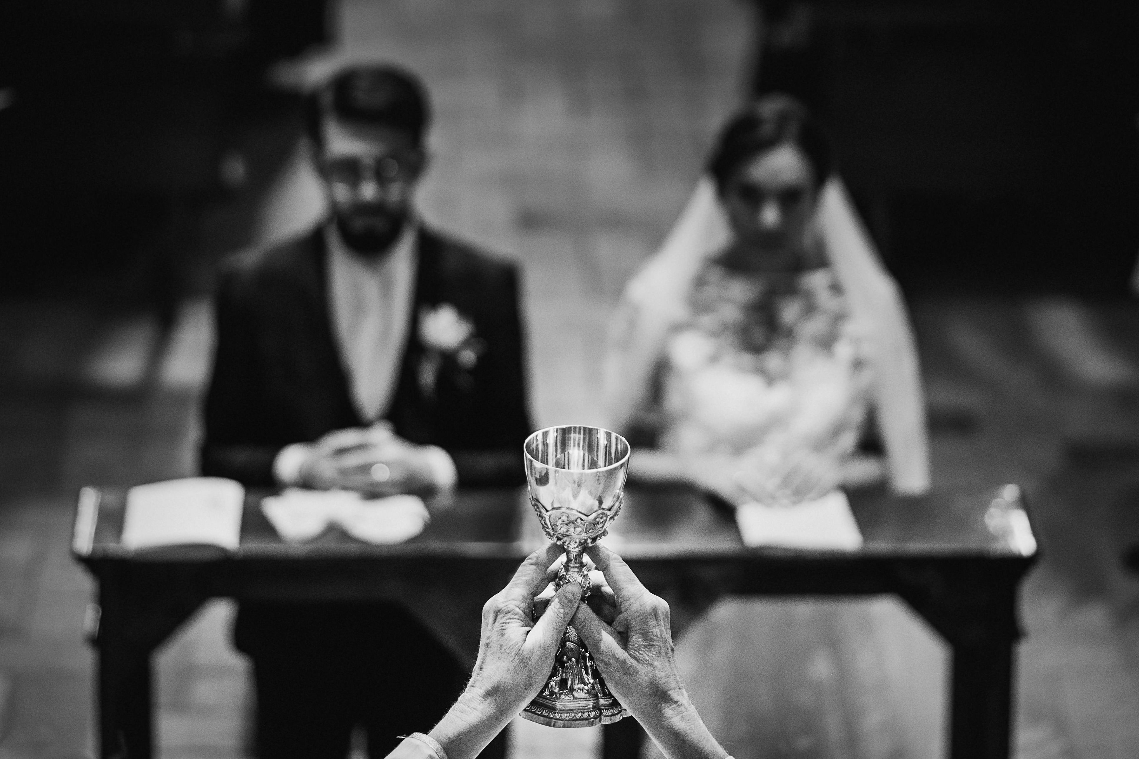 Catholic cup raised during wedding ceremony - photo by UK documentary wedding photographer Andy Gaines Photography