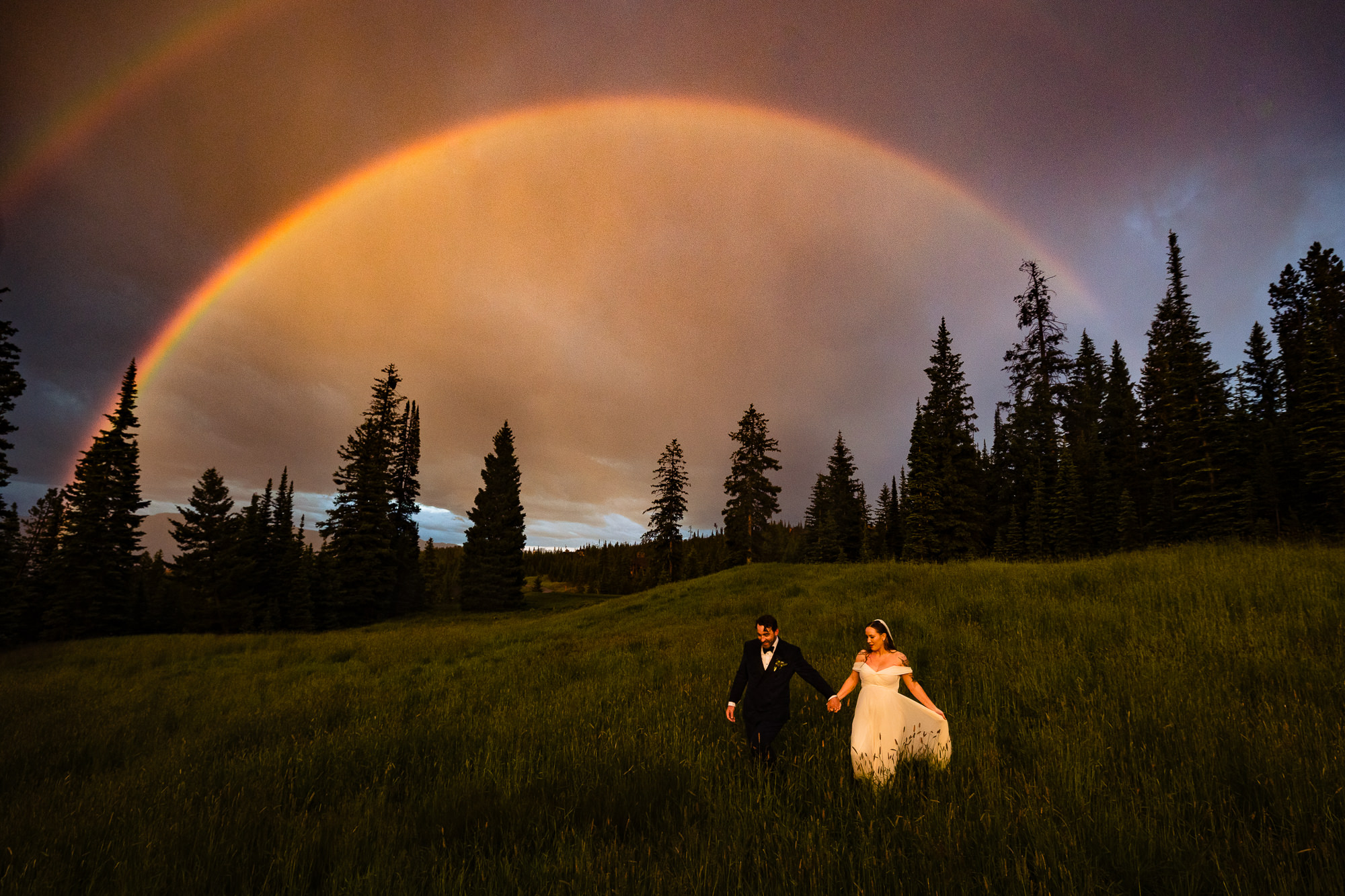 Couple in field against rainbow - photo by Montana wedding photographer David Clumpner