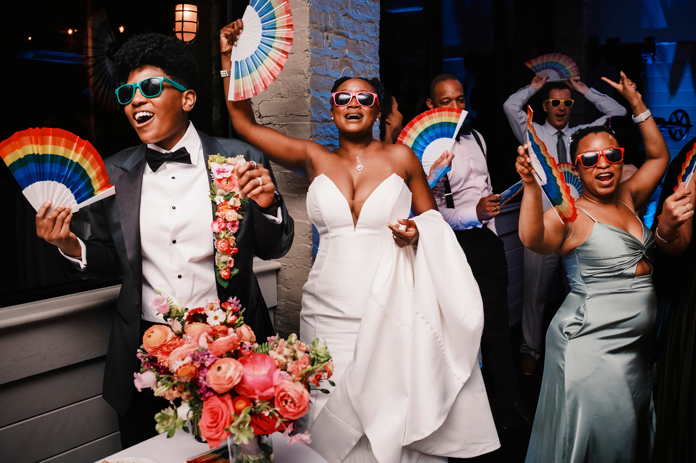 Bride and groom with  wedding party dancing with colorful fans  - photo by Chrisman Studios