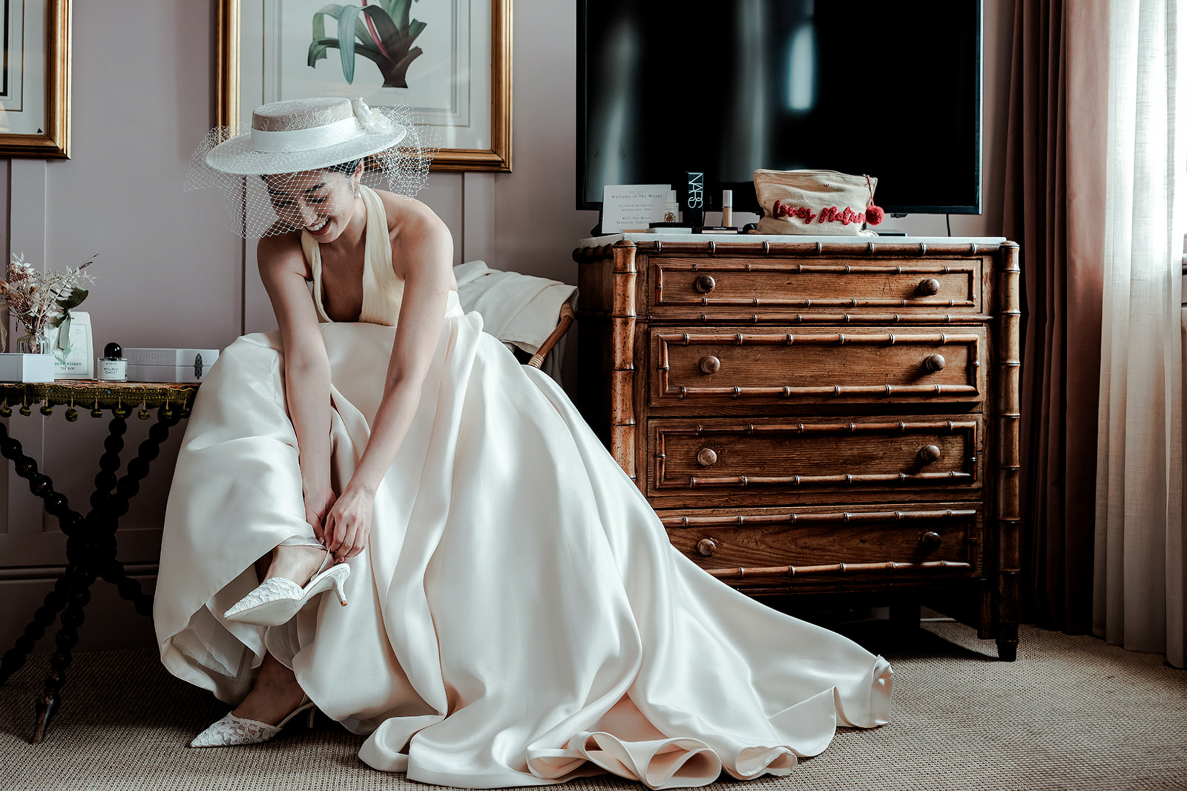 Bride in fashionable gown and hat getting ready - photo by Oliver Holder Photography 