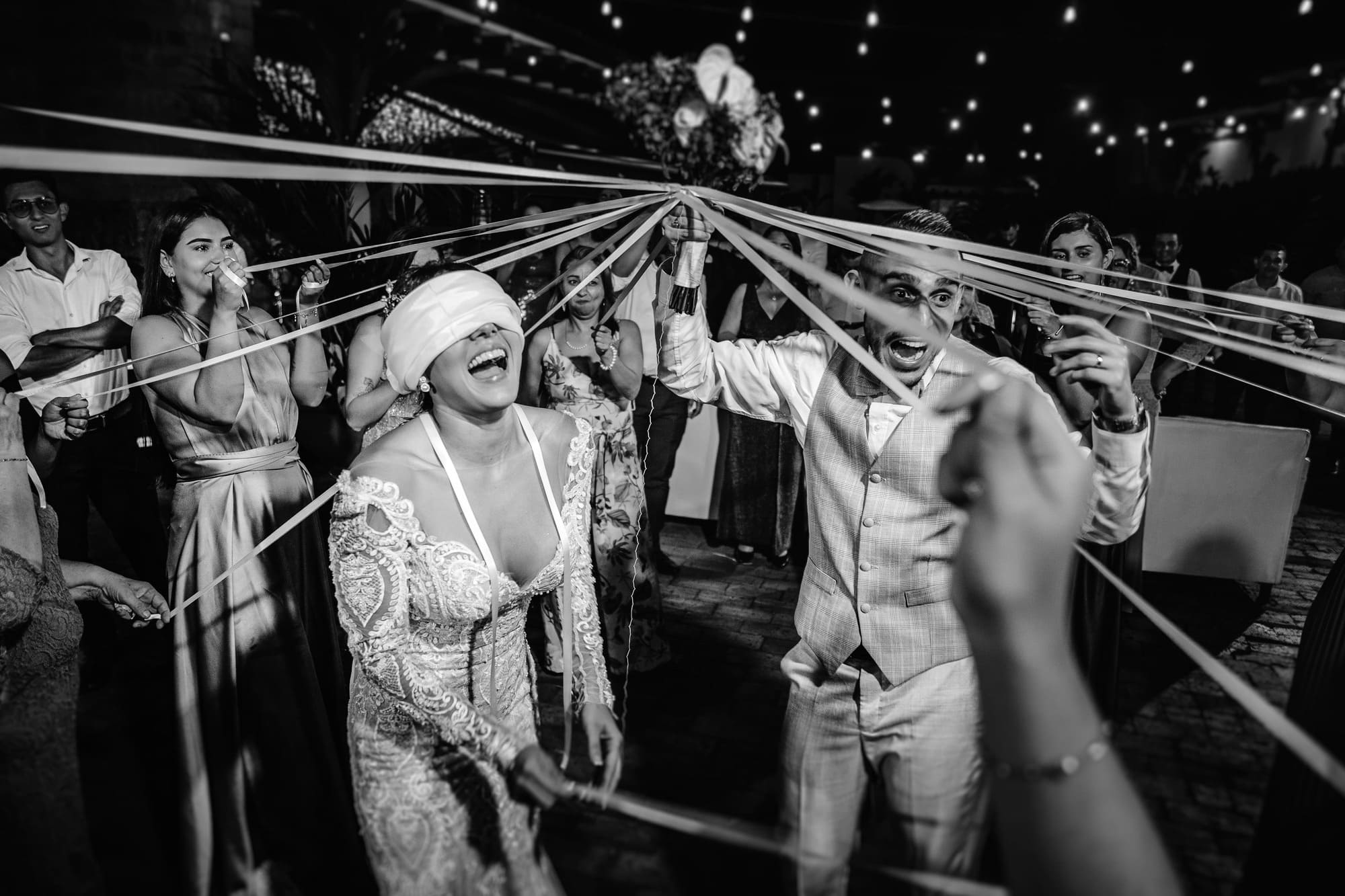 Blindfolded bride during party - photo by John Palacio Photography