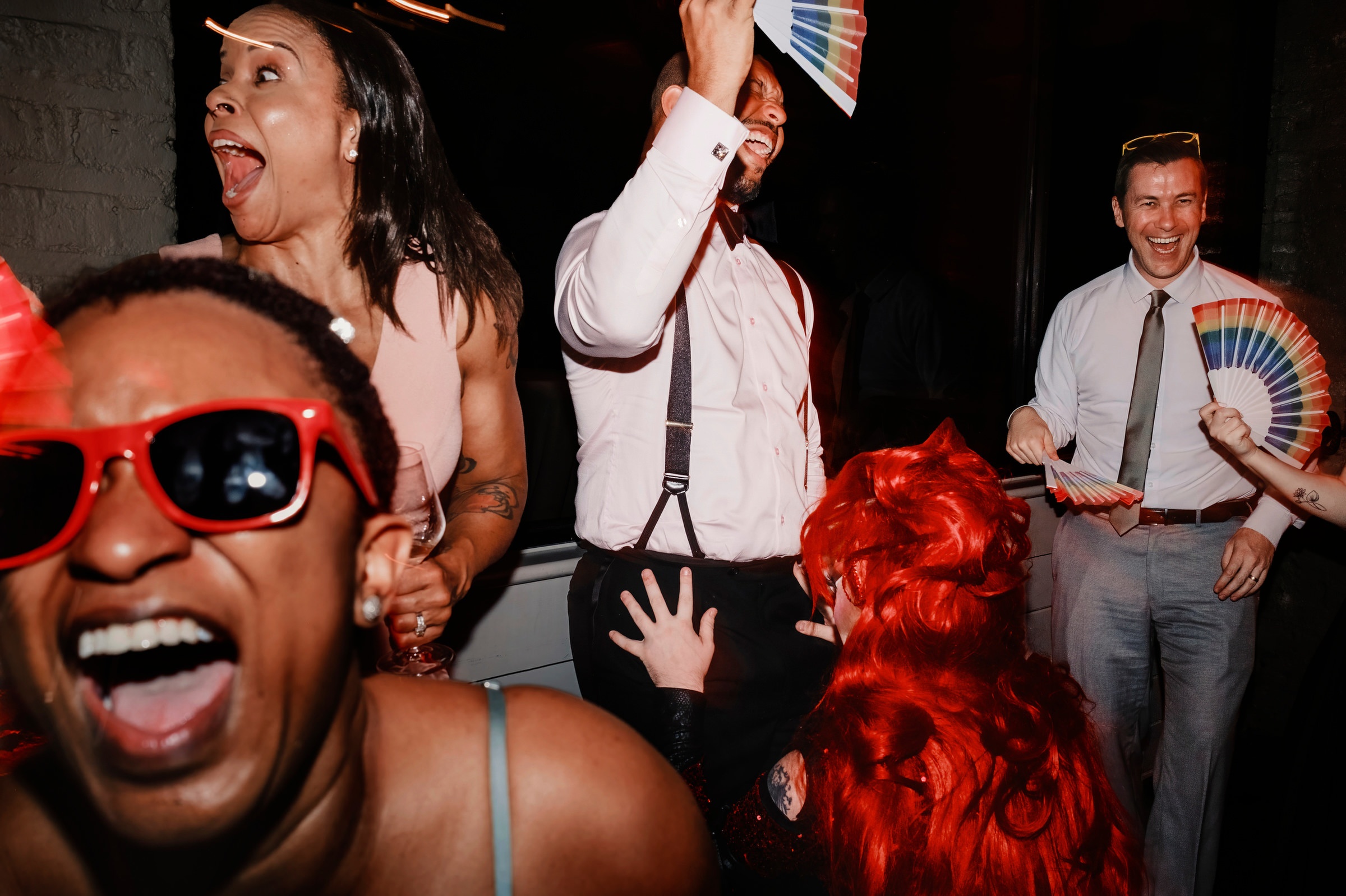 Fun party moment with colorful fans - photo by Charleston, SC and destination wedding photographer Chrisman Studios