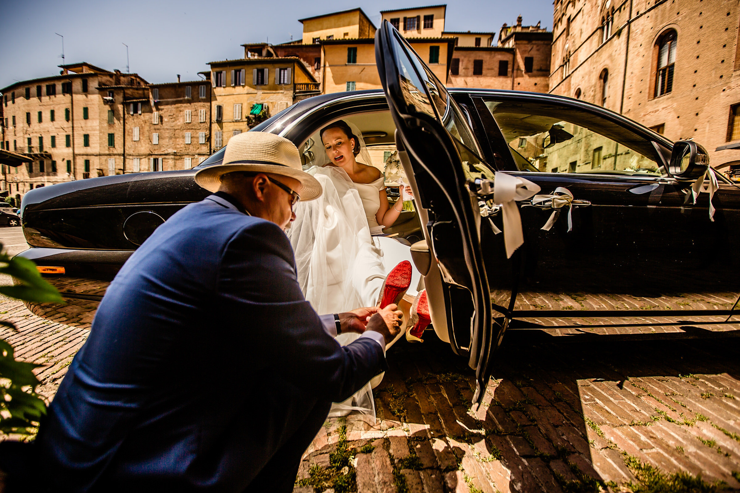Groom putting bride shoes on in limo - photo by Netherlands documentary wedding photographer Eppel Photography