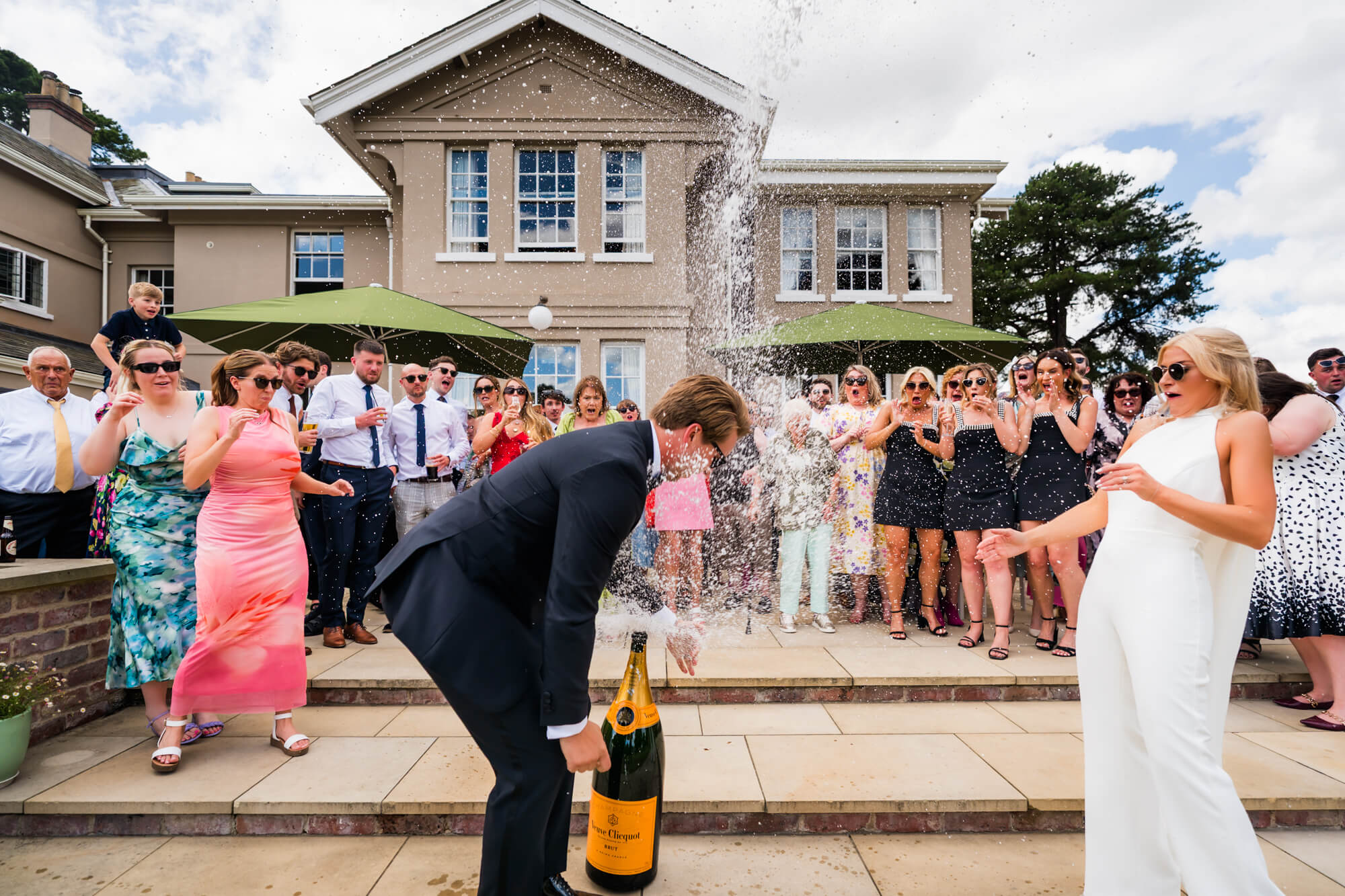 Whoops champagne splashing on groom - photo by Kirsty Mattsson Photography