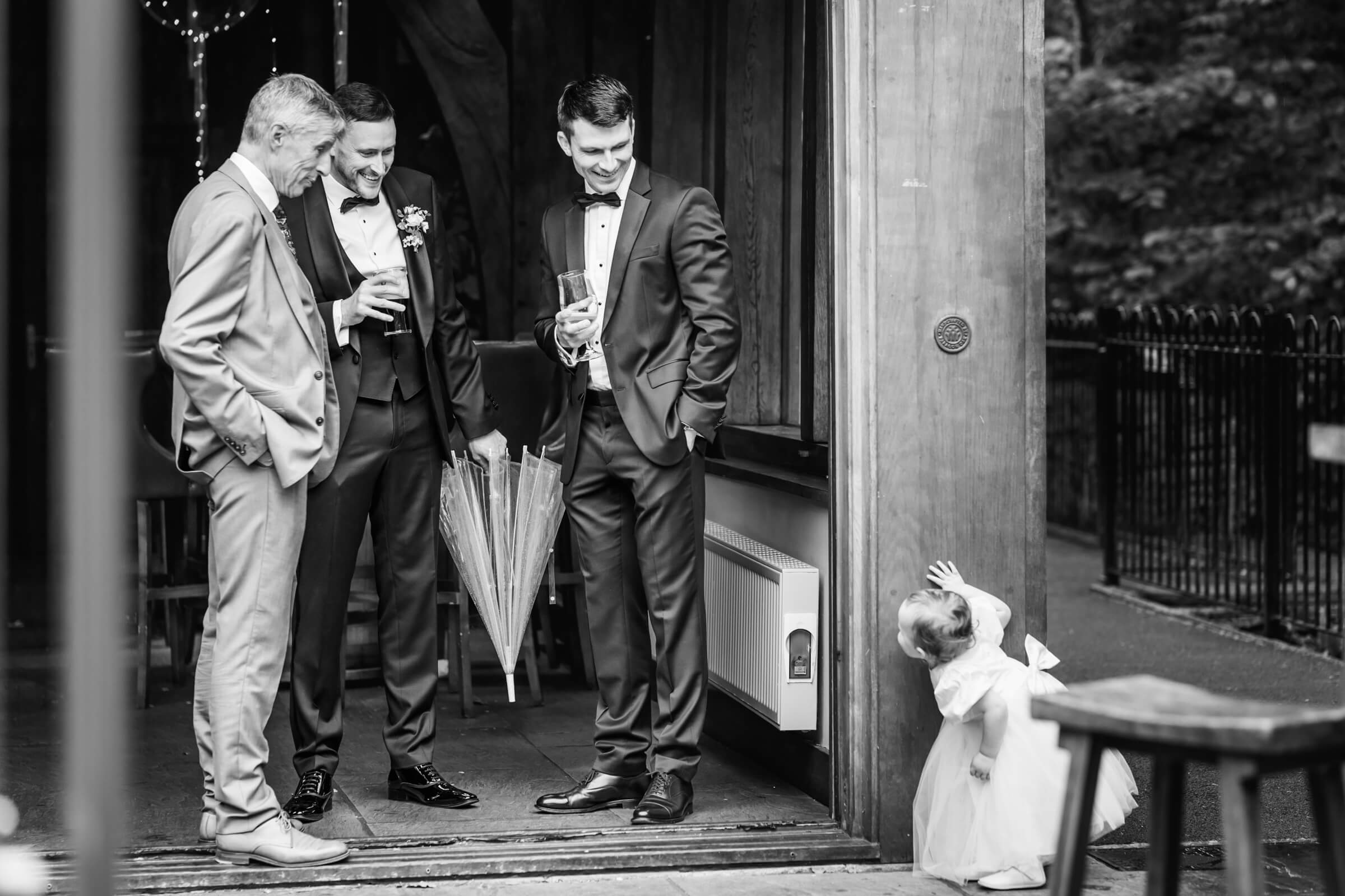 Baby looks around the corner, photo by Kirsty Mattsson Photography, UK documentary wedding photographer
