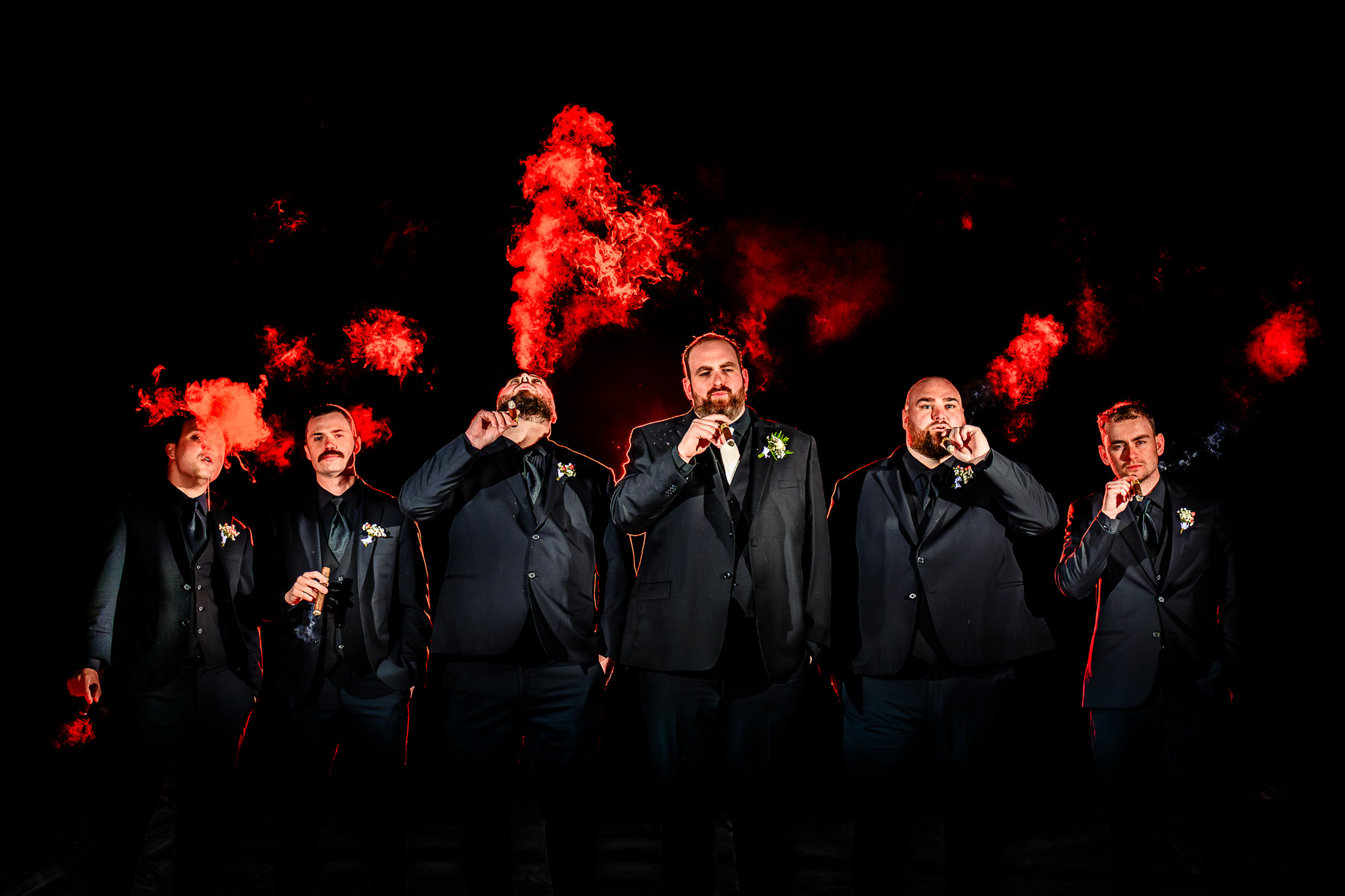Groomsmen smoke cigars with red smoke- photo by Eaton Photo - Vermont Wedding Photographer