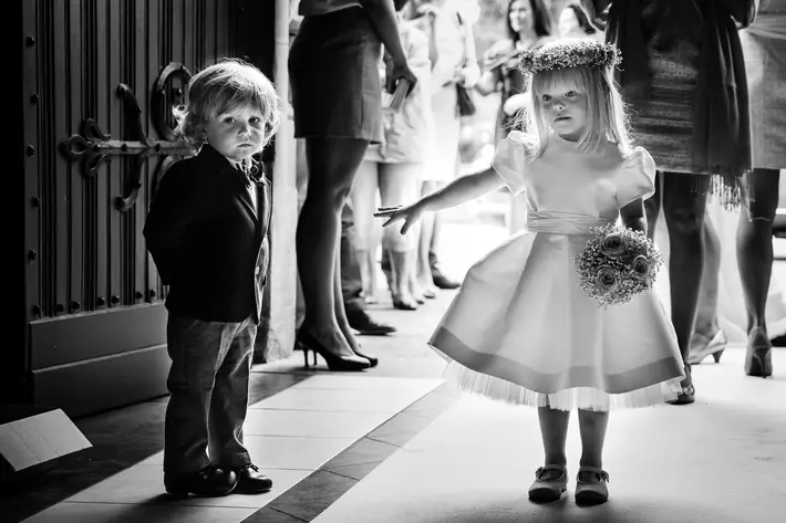Adorable flower girl helps brother down the aisle - photo by Yves Schepers