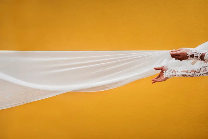 Creatively captured photo of bride's hands catching veil by Fer Juaristi 