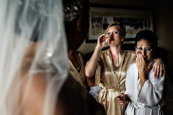 Funny photo of sister and mom drinking and crying while bride gets ready - photo by JAG Studios