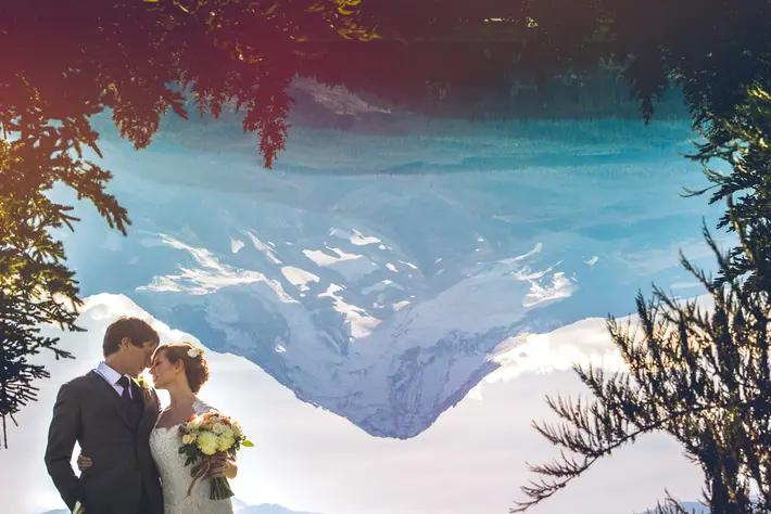 Couple portrait with reflected snow-capped mountain by Jeff Newsom