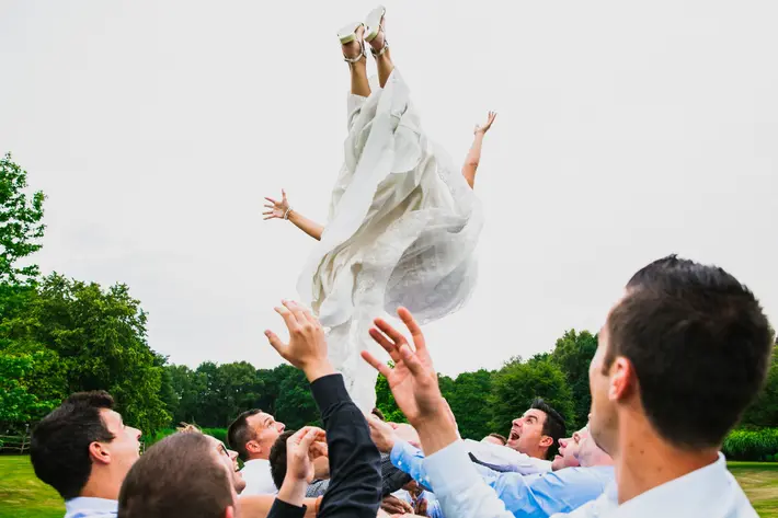 Groosmen throw bride in the air - photo by Philippe Swiggers