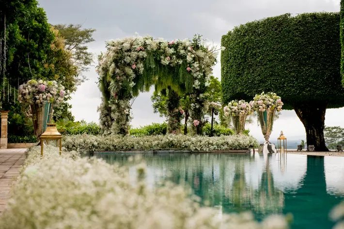 Poolside luxuy wedding floral arbor of white roses photographed by Morgan Lynn Razi