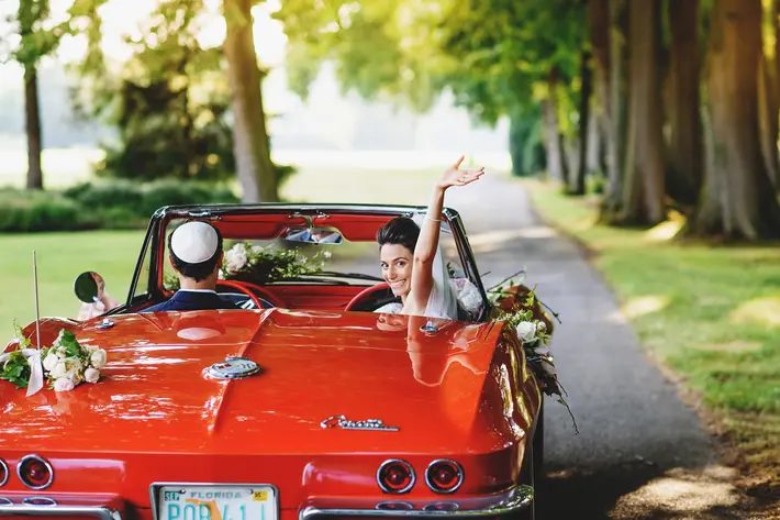 couple-leaves-ceremony-in-little-red-corvette-worlds-best-wedding-photos-ross-harvey-london-wedding-photographers