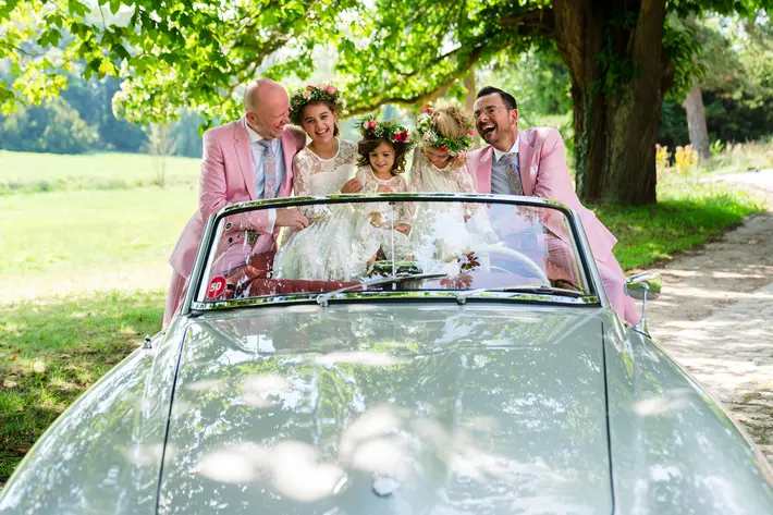 grooms-and-flower-girls-in-convertible-worlds-best-wedding-photos-by-philippe-swiggers