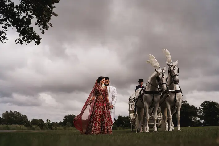 Elegant Indian wedding couple with decorated white horses - photographed by Rahul Khona of F5 in London