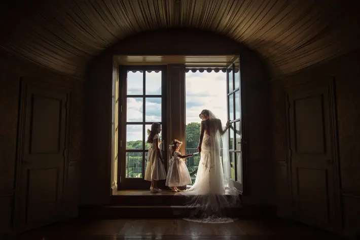Flower girls in lace dresses with bride at window - photo by Cliff Mautner - PA