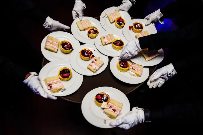 Waiters with white gloves pass dessert plates at reception - photo by JAG Studios - NYC