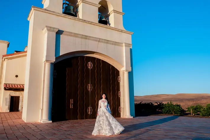 Bride-wearing-dramatic-lace-long-sleeve-gown-in-front-of-church-johnandjoseph-los-angeles