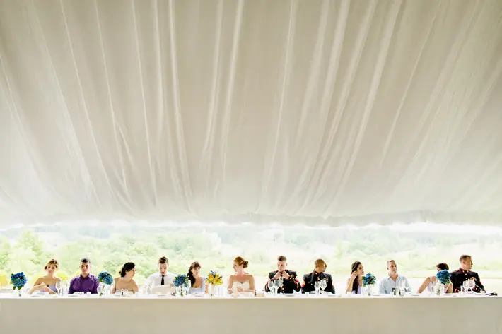 bridal-party-at-long-table-under-big-white-tent-procopio-photography
